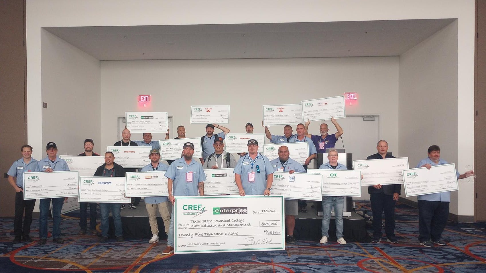 Award recipients present their checks from the Collision Repair Education Foundation during the CREF Benchmark Awards Breakfast on Wednesday, Nov. 5, at the SEMA Show in Las Vegas.