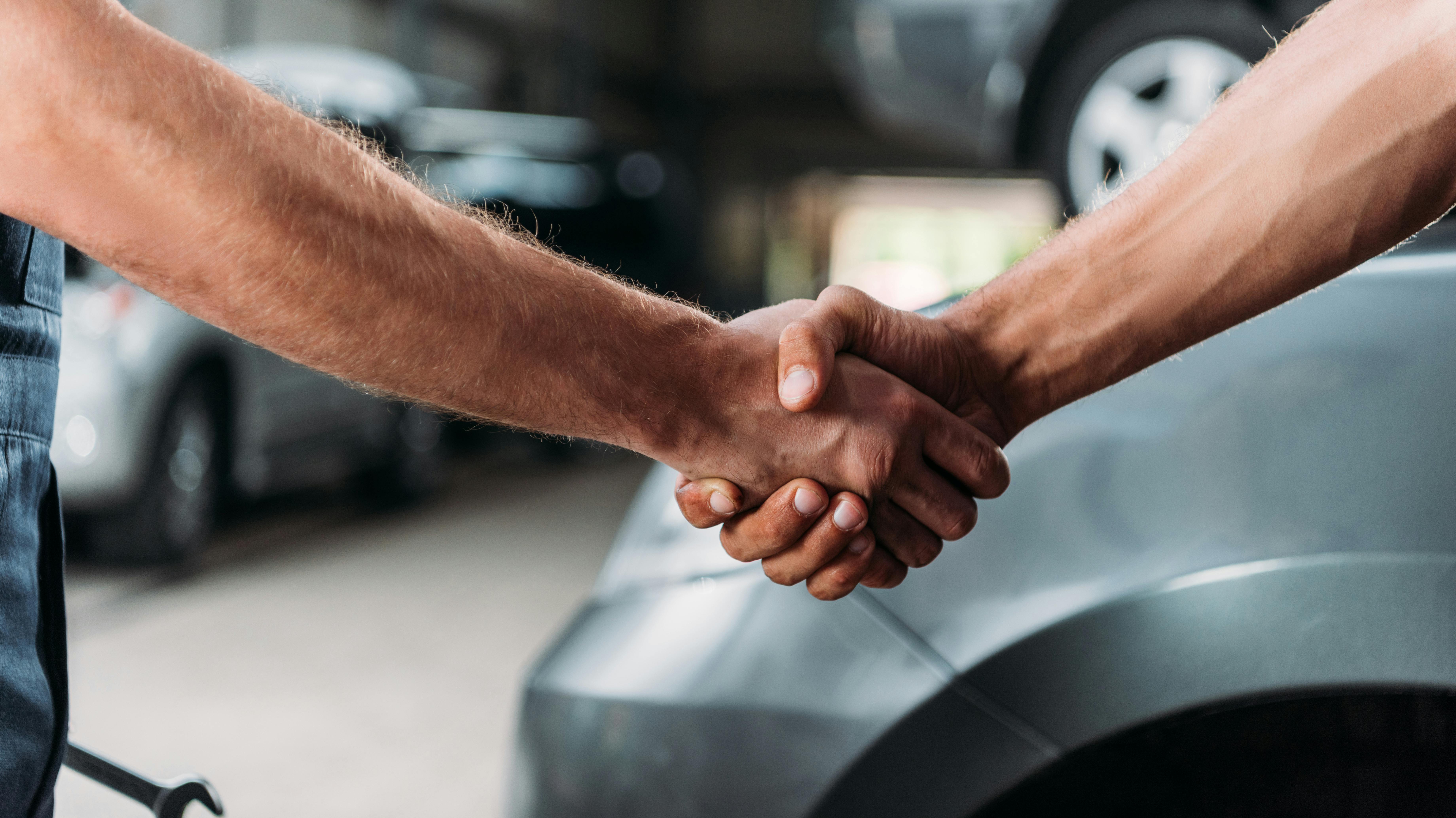 Shop owner and customer shaking hands in shop