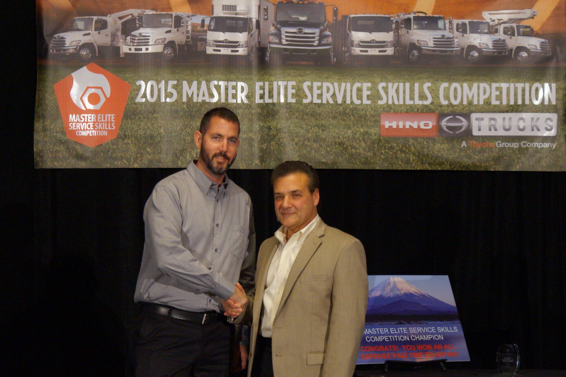 Tom Marchini of Hino Trucks right congratulates Hino Trucks Service Skills Competition champion David Taylor of K Neal left