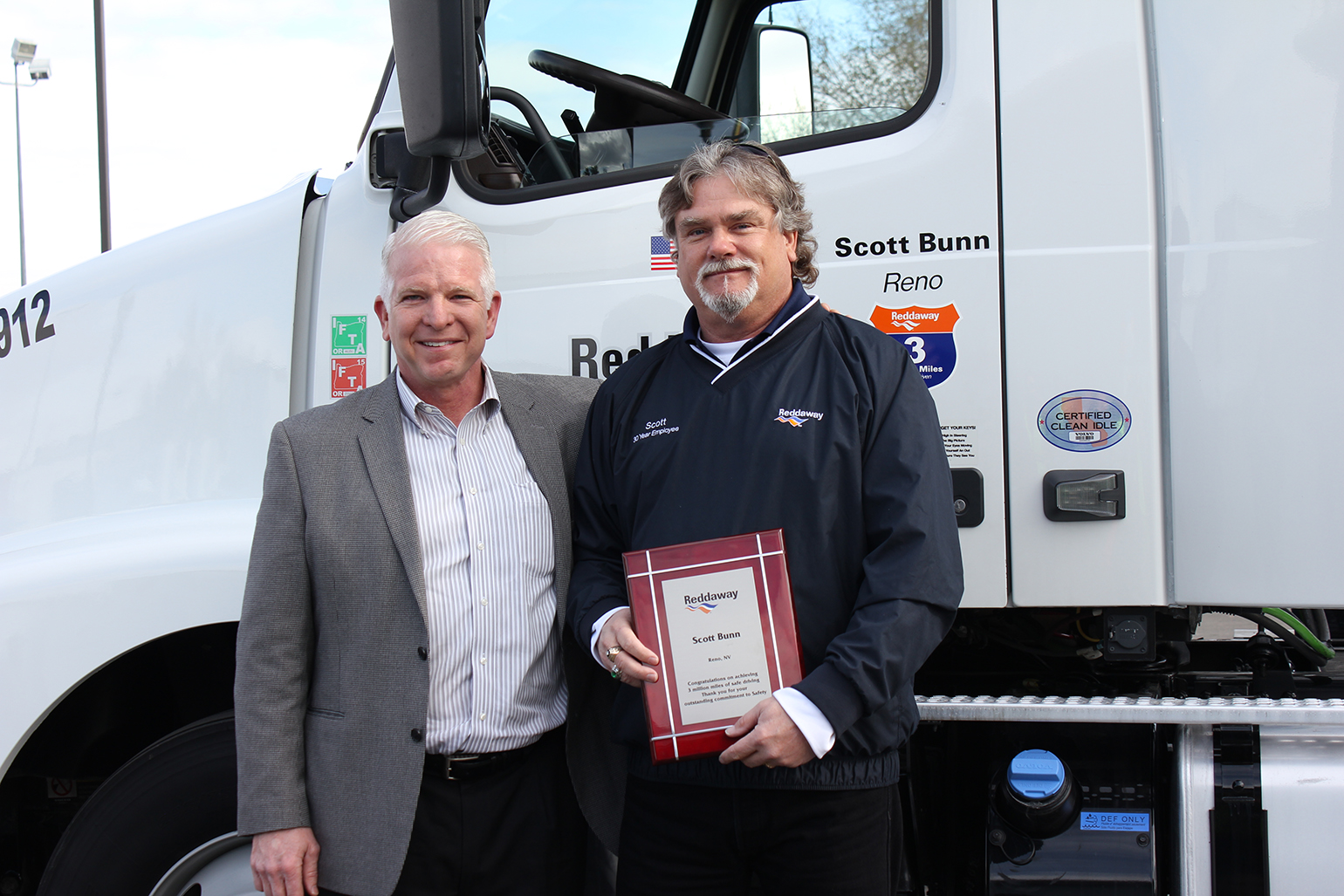 Reddaway President and CEO T J O39Connor left stands with driver Scott Bunn at a ceremony this week recognizing Bunn for reaching 3 million miles without a preventable accident Photo courtesy Reddaway