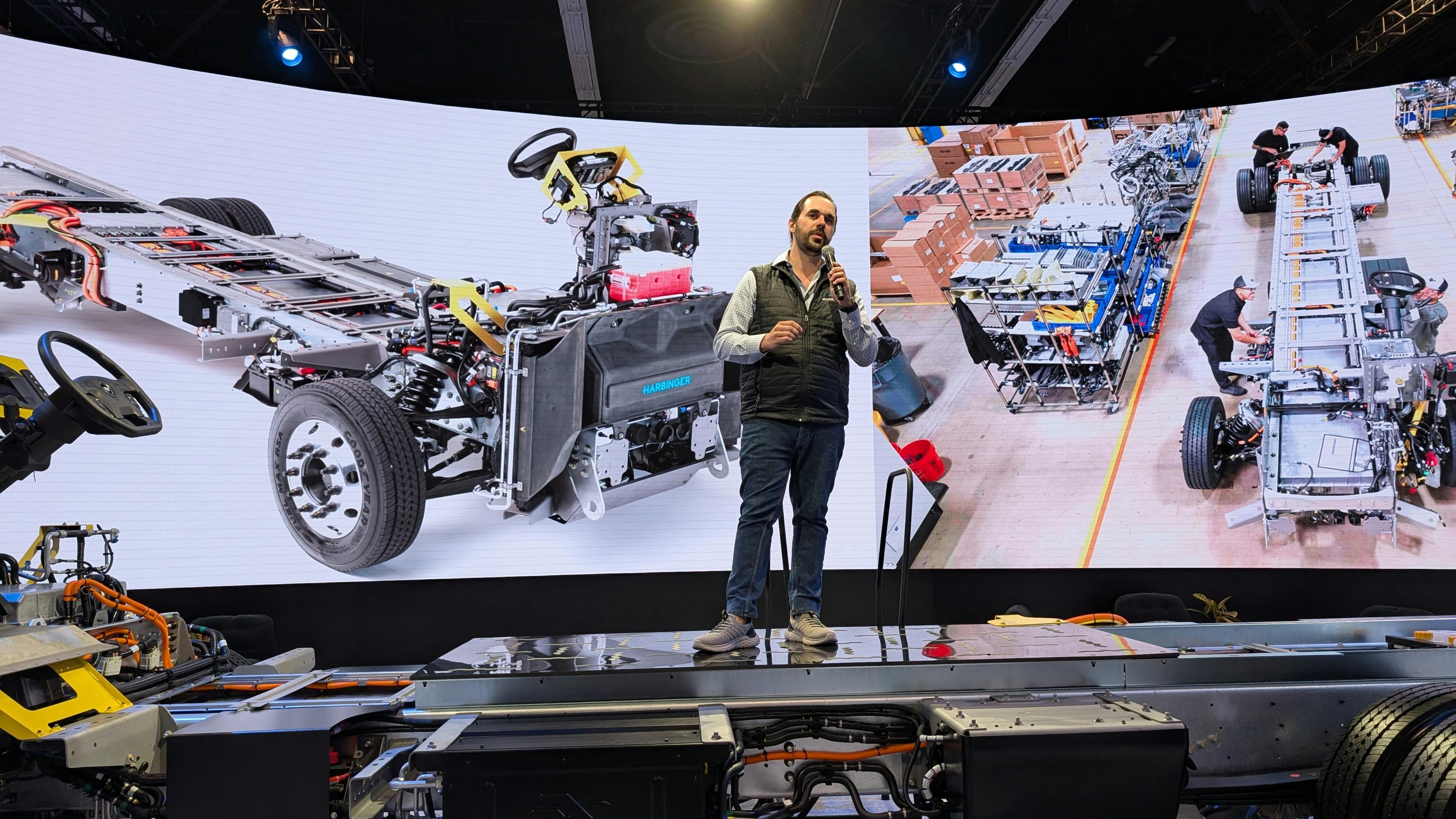 Harbinger CEO John Harris stands on his medium-duty truck hybrid chassis during ACT Expo in Anaheim, California. He said the vehicle could get up to 500 miles between charges.