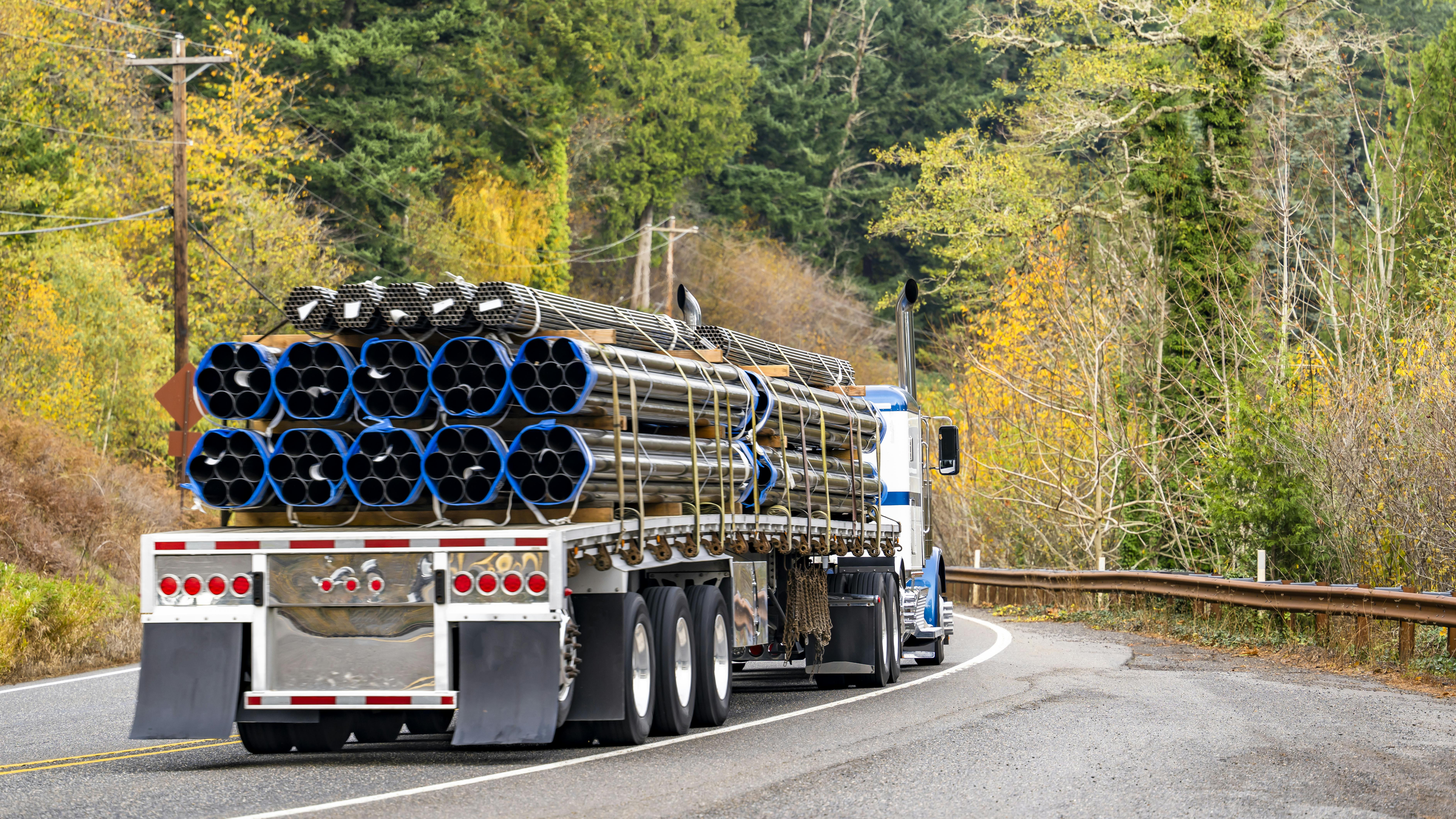 flatbed hauling metal pipes
