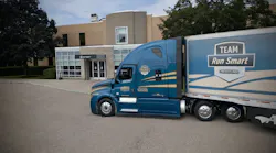 A blue and yellow Albert Transport Freightliner Cascadia truck pulling a Team Run Smart trailer. A blue and yellow Albert Transport Freightliner Cascadia truck pulling a Team Run Smart trailer.