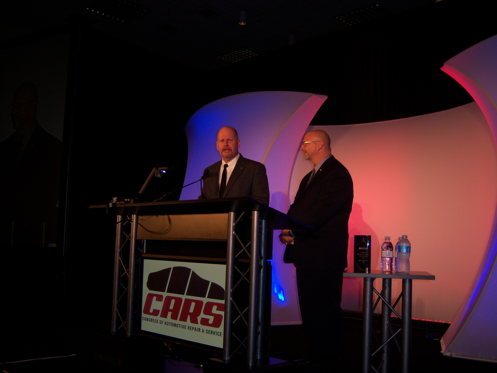 Bill Moss, left, CARS chairman, joins Ron Nagy, NACE chairman, in welcoming attendees to the opening general session of Automotive Service & Repair Week at the Morial Convention Center in New Orleans, La.