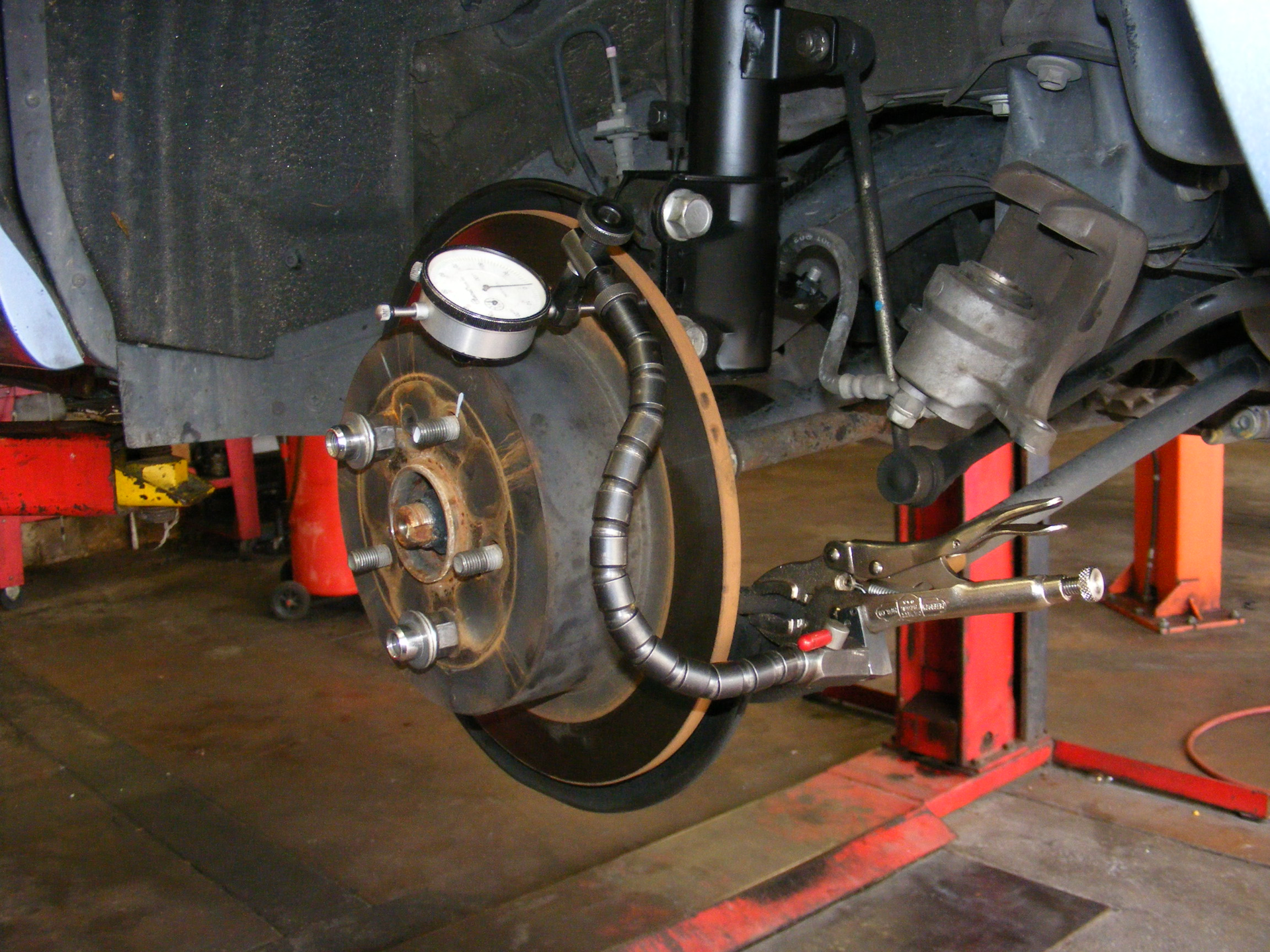 Use extra care when using magnets around ABS speed sensors, as the magnets can affect performance of the speed sensor. Here, a clamping mount is used, instead of a magnet mount, when checking rotor run-out with a dial indicator.