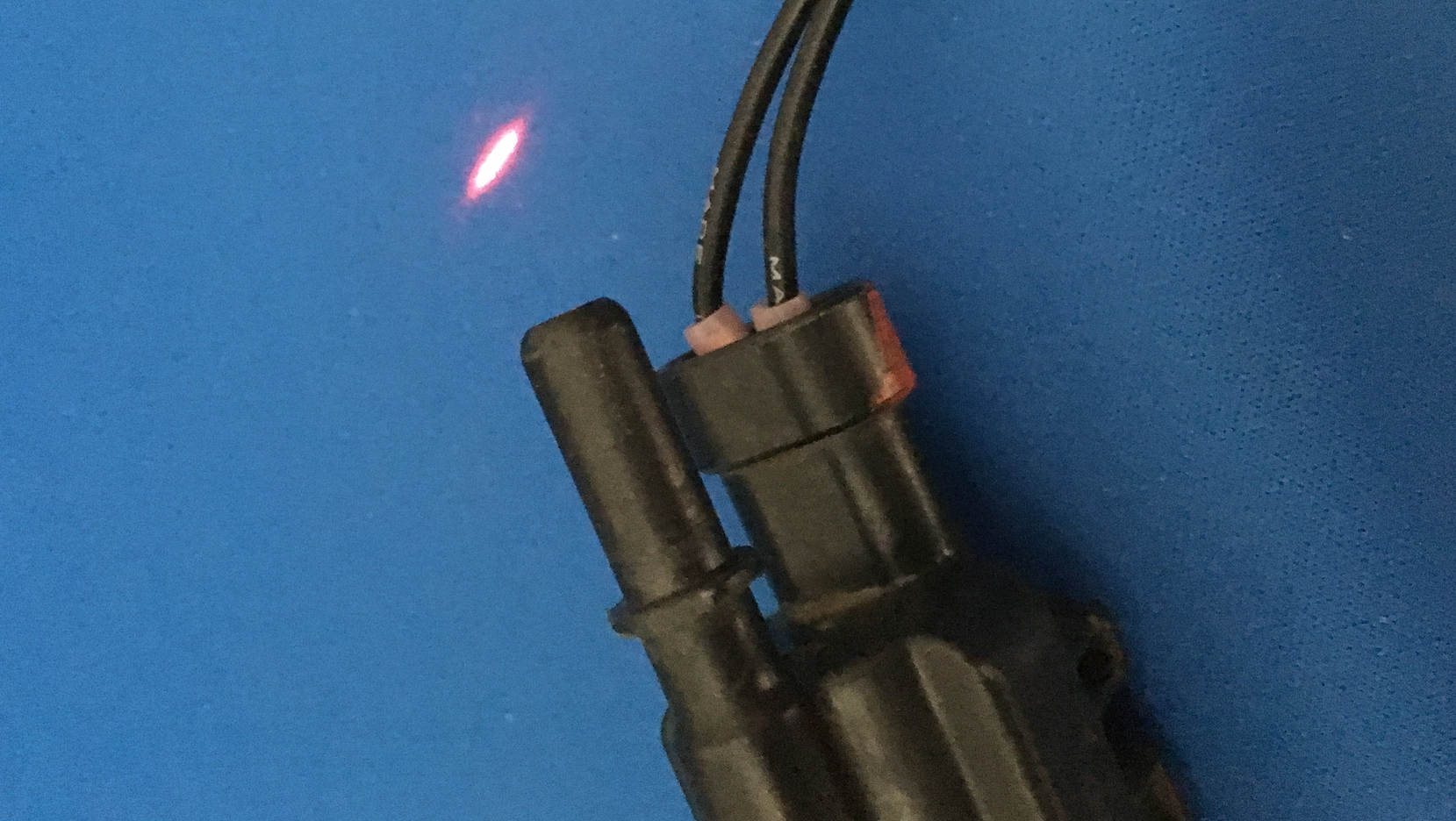 In order to see a small leak, one trick that may work is to dim the lights in the shop and use a laser pointer along the EVAP lines, which will highlight the smoke trail. Here, the laser pointer highlights the leak from an EVAP solenoid.