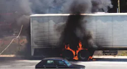 Truck wheels on fire on the side of a highway with firefighters on scene to extinguish the blaze. Truck wheels on fire on the side of a highway with firefighters on scene to extinguish the blaze.