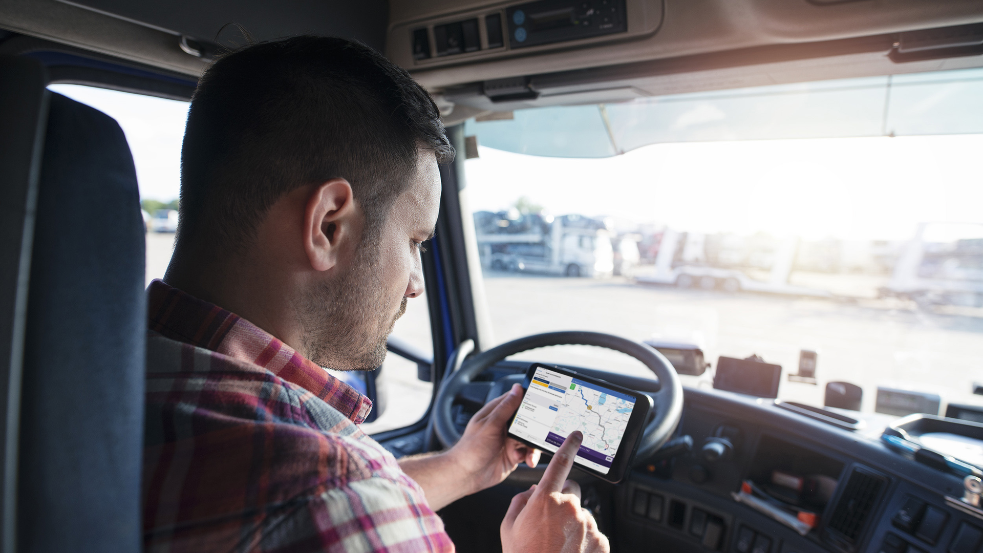 A truck driver uses an Eleos Technologies app on a smartphone. Eleos creates custom mobile apps for trucking companies to tailor the work experience for their drivers.