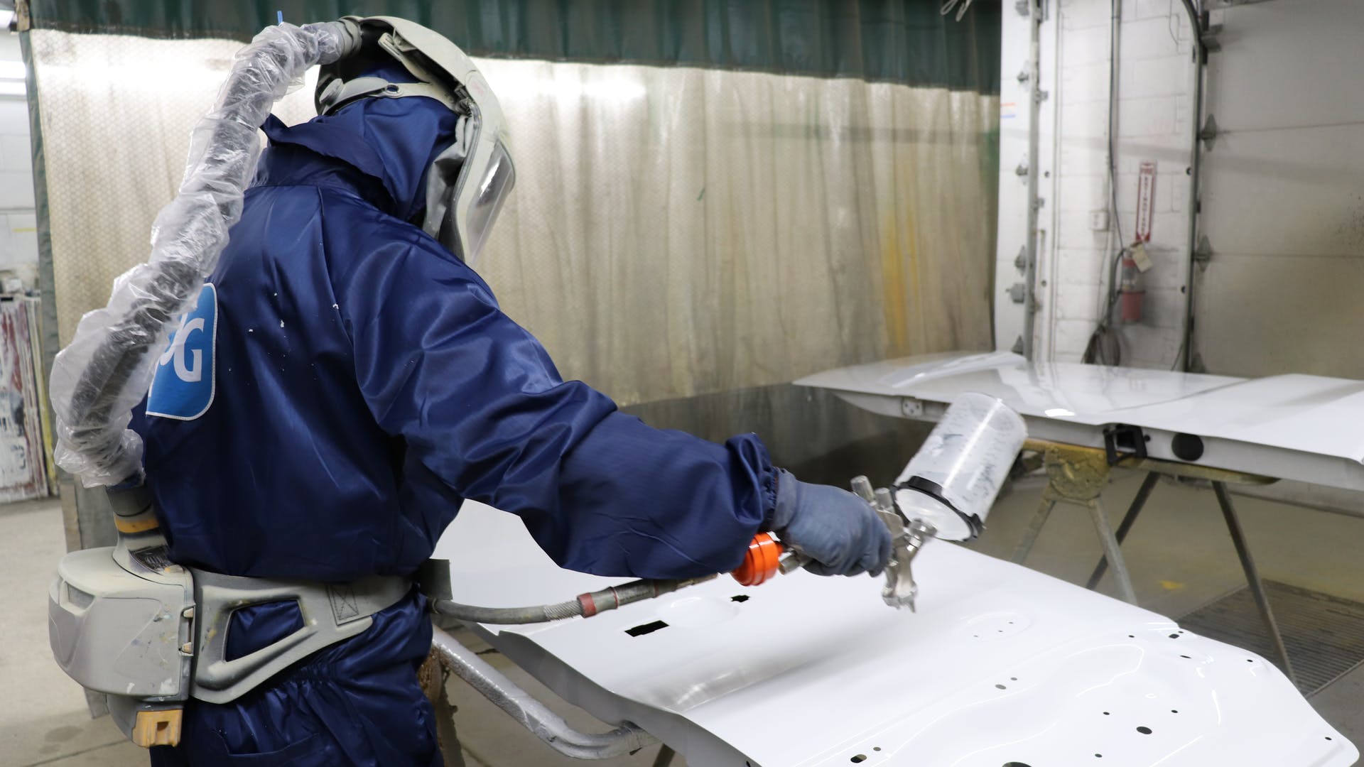 Fleet Fast's Francisco Esquivel dons his painting suit to apply a clear coat.