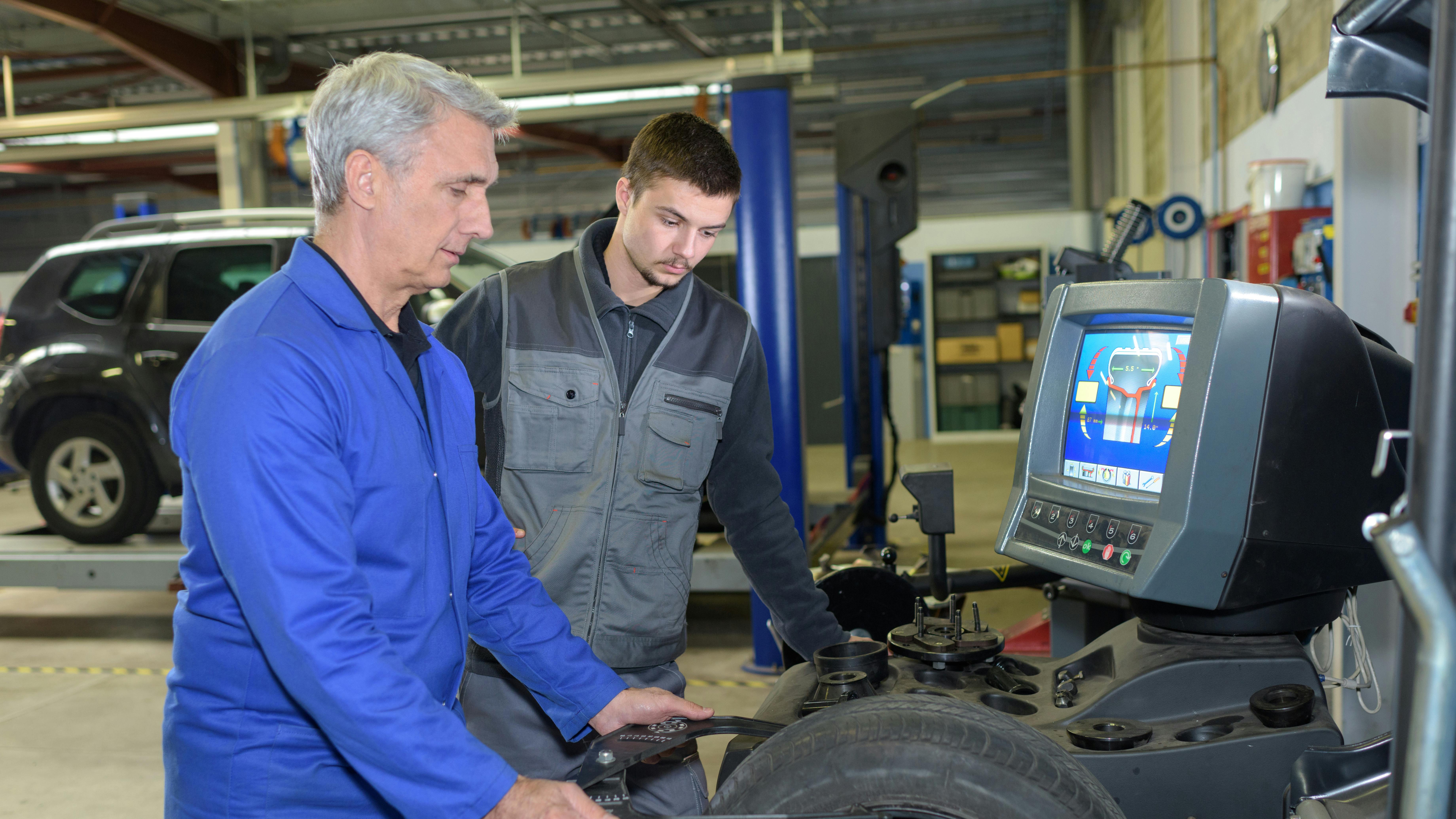 Dreamstime mechanic teaching young technicain