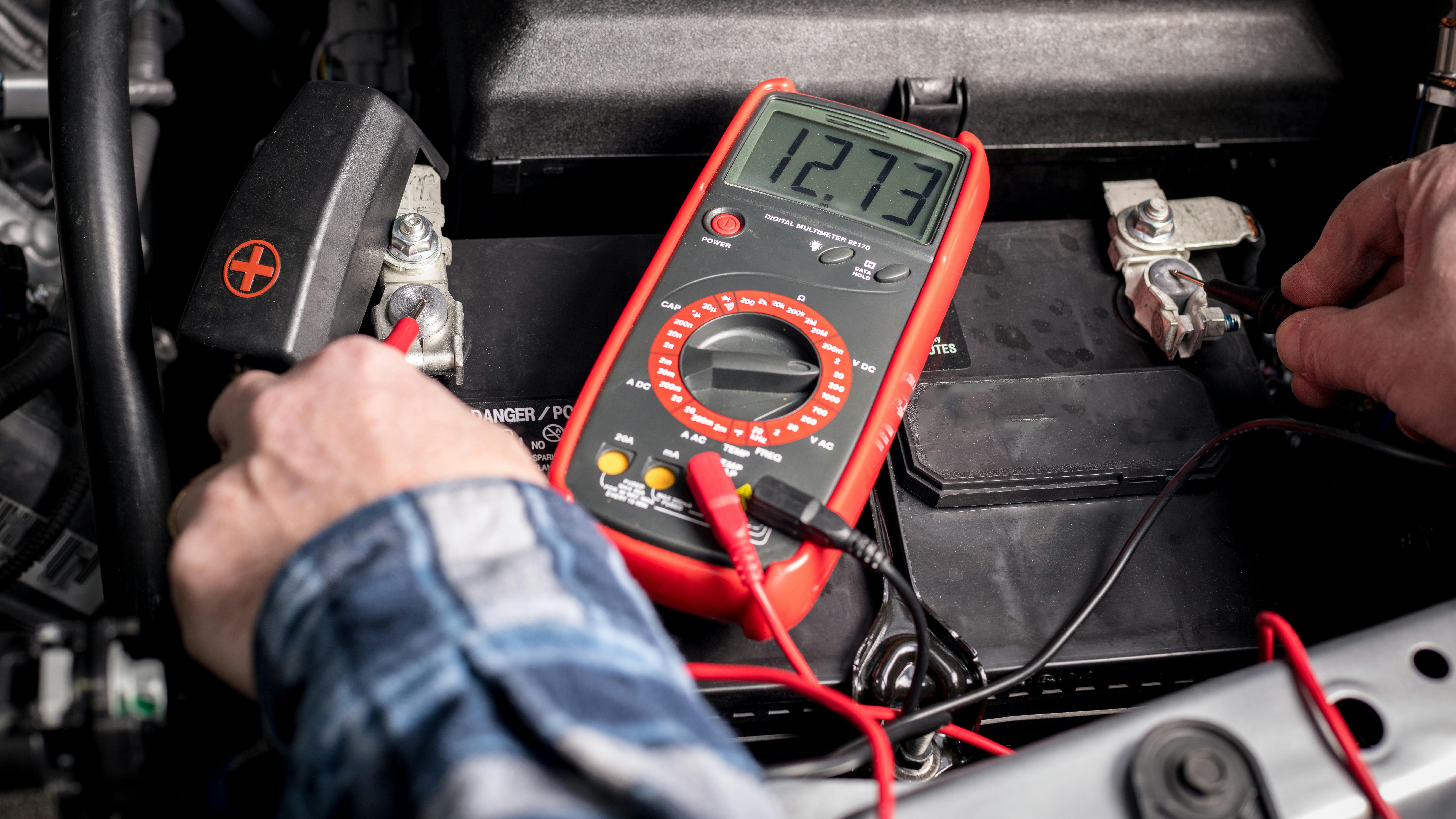 Technician testing truck battery