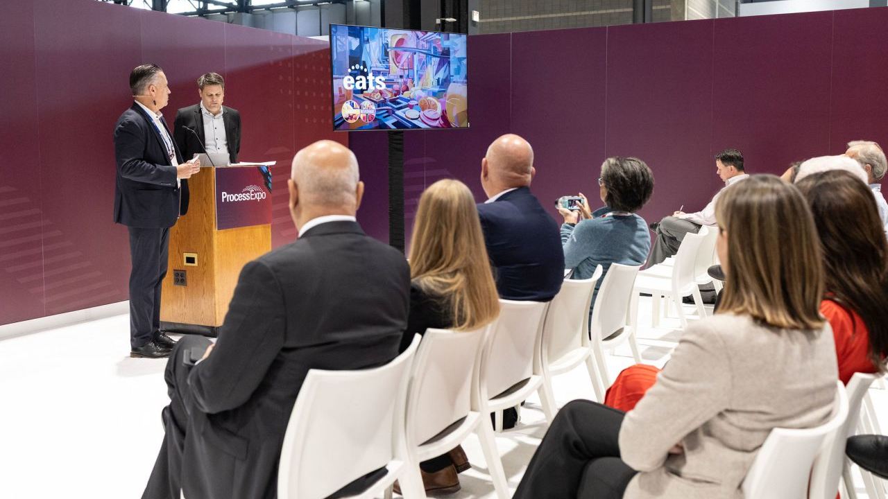 Matt Malott, president/CEO of Multivac Inc. (at podium, left) and Constantin von Vieregge, president and CEO, Messe Frankfurt Inc., discuss the rebranding of Process Expo to EATS with assembled media and stakeholders during Process Expo 2023 in Chicago, Oct. 23, 2023.