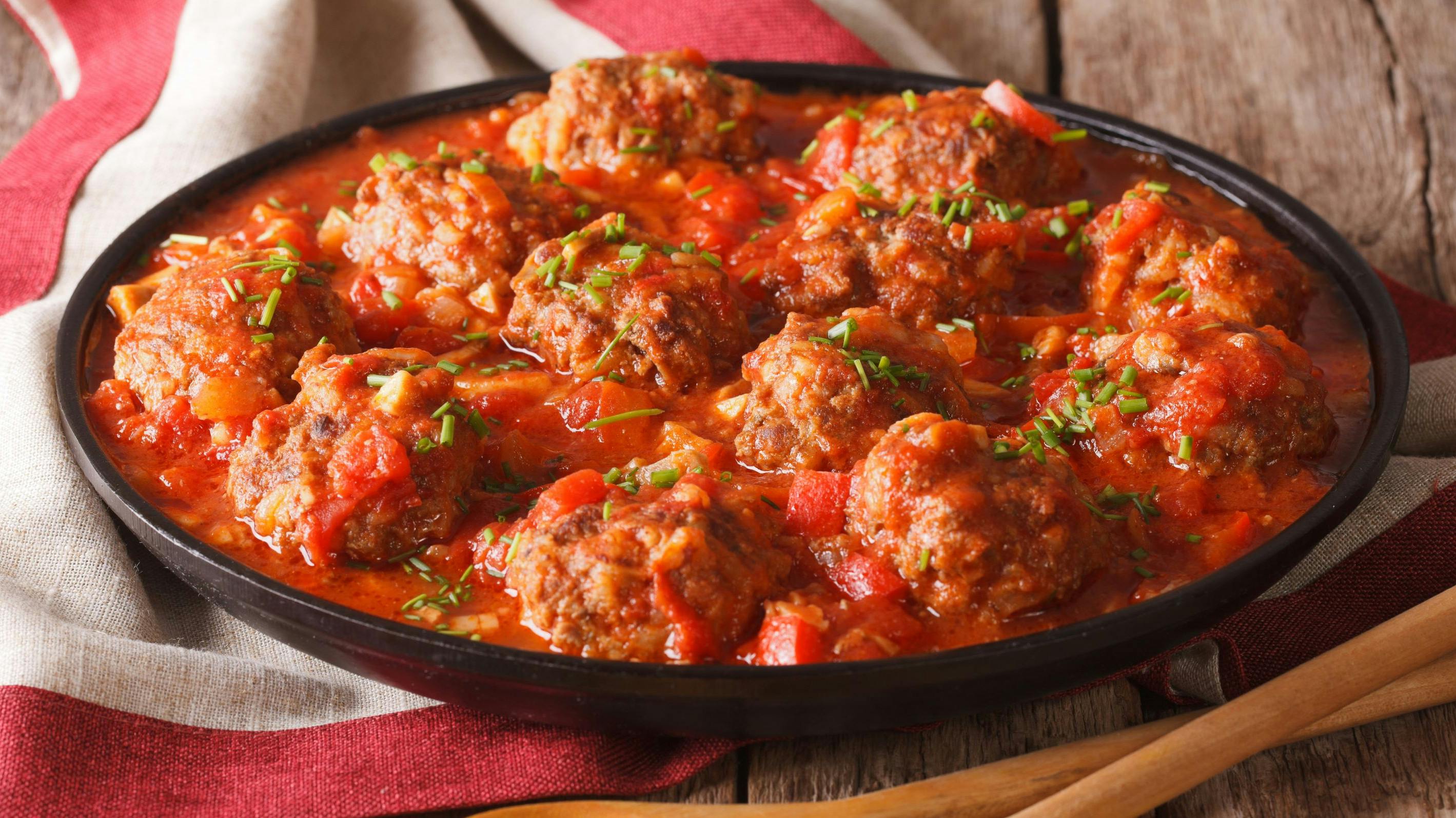Albondigas meatballs with tomato sauce on a plate on a table close-up. horizontal