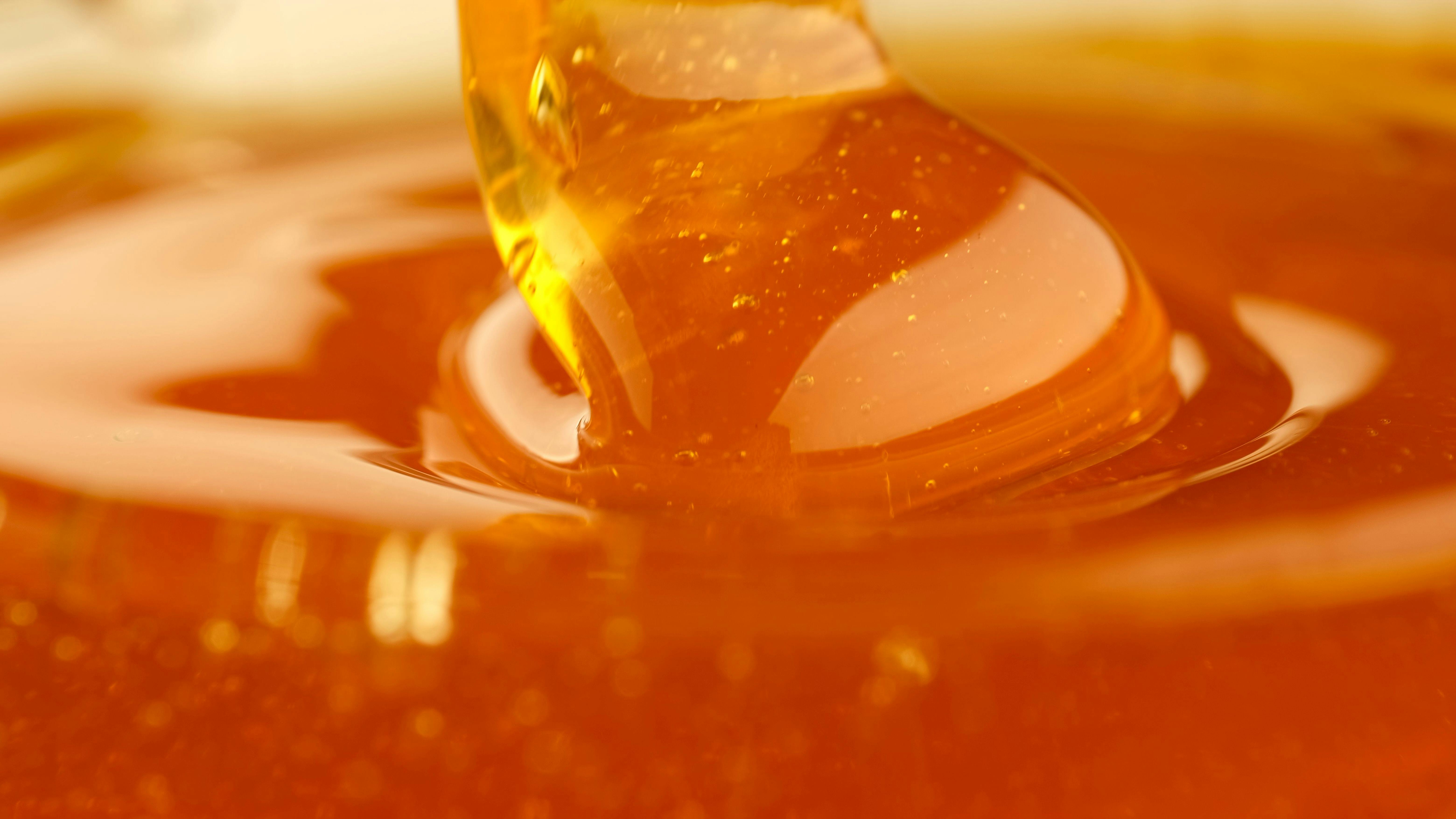Pouring honey, flowing liquid sugar syrup. Thick Honey Dripping close up