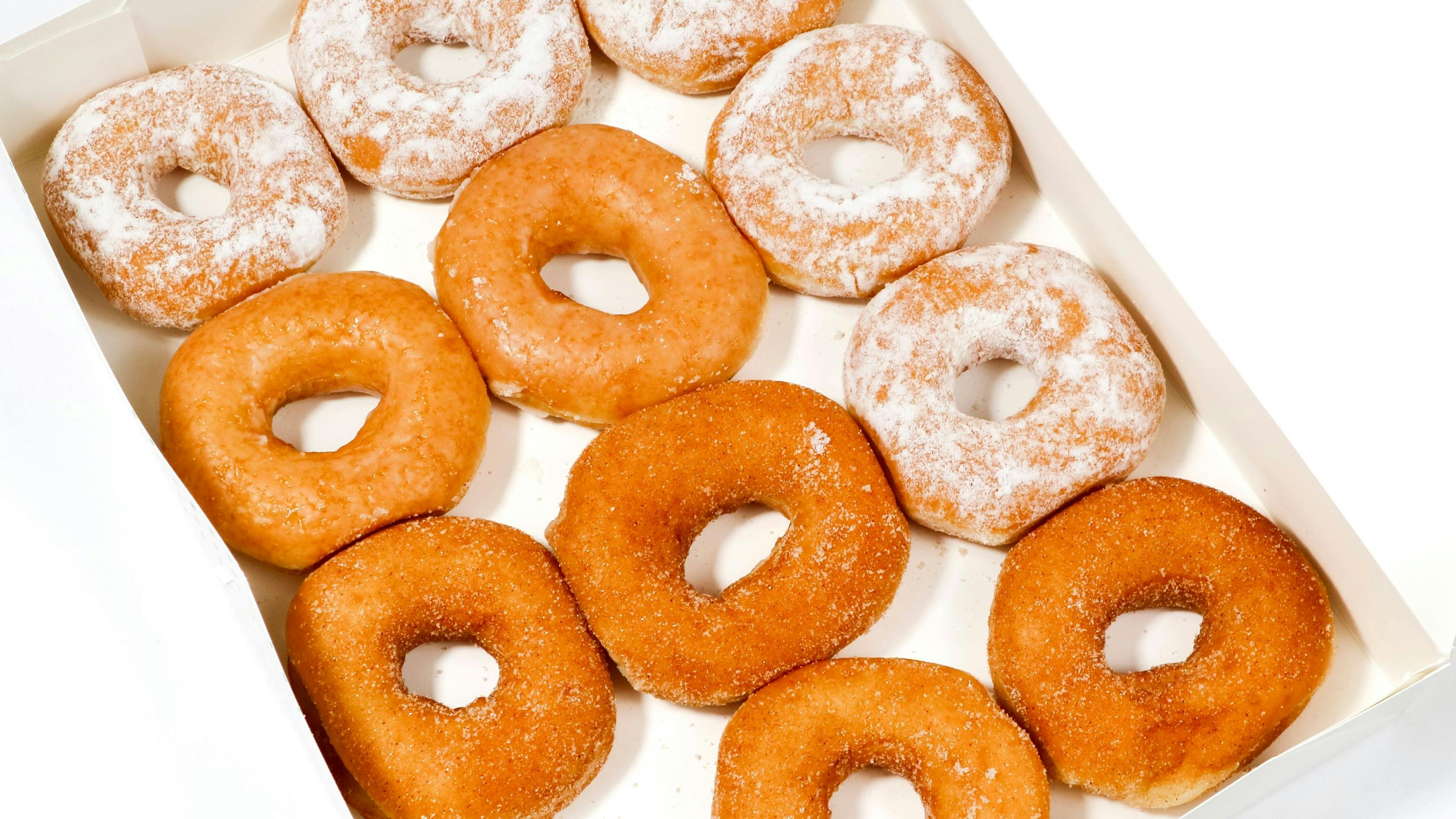 two separate boxes filled with a variety of donuts.