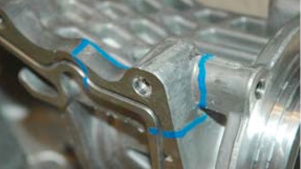 Blue paint outlines the areas of material andor structural vulnerability in an aluminum casting