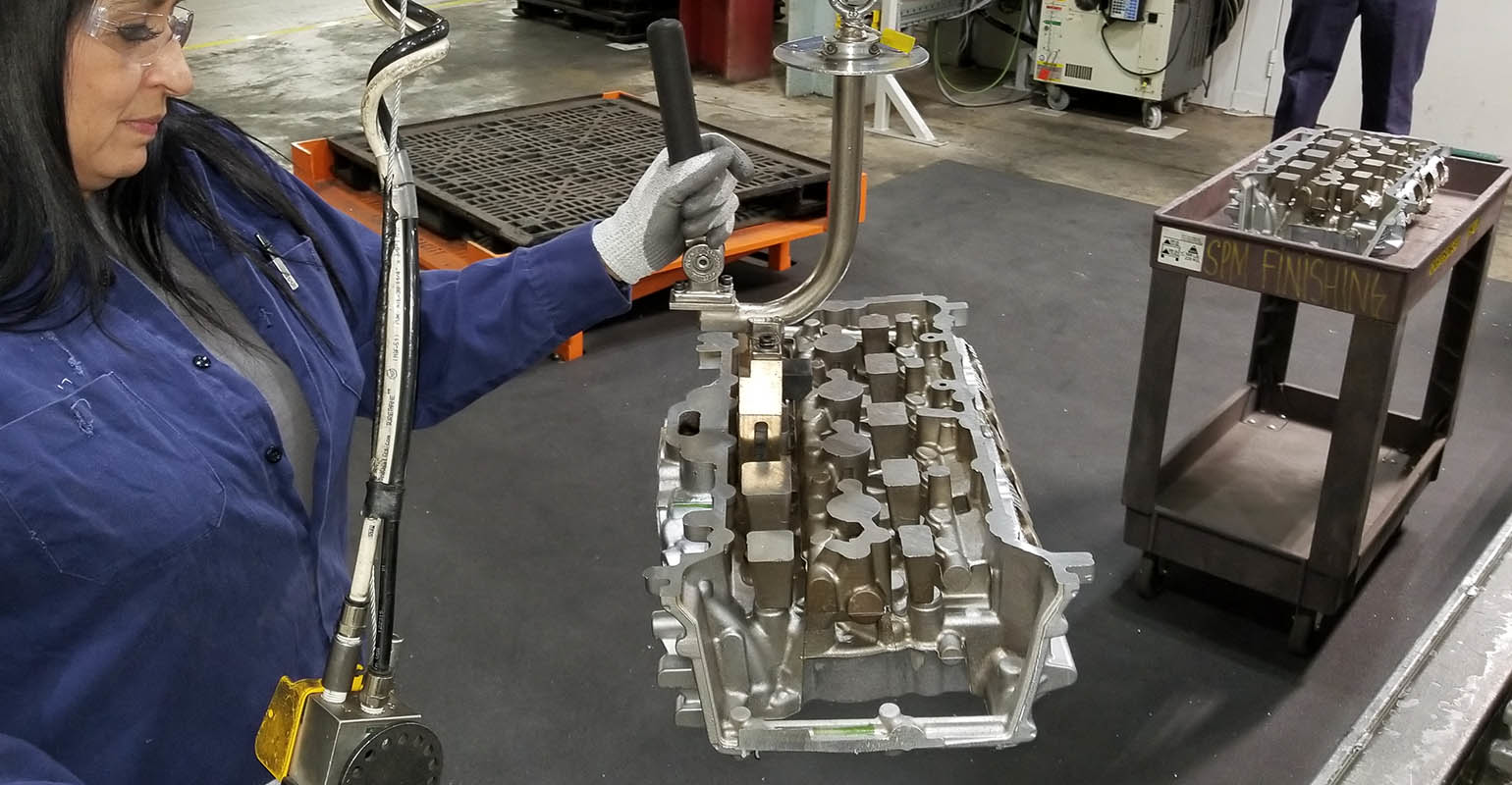 Finishing a semi-permanent mold cast cylinder head at GM's Defiance Casting Operations.
