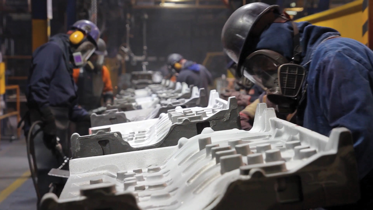 Workers grind engine castings at Teksid Hierro, a gray and ductile iron foundry.