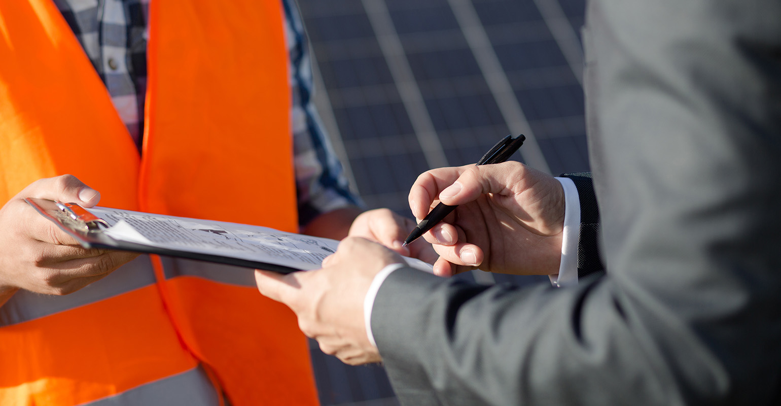 Close up view on foreman and client signing power contract at solar power station.
