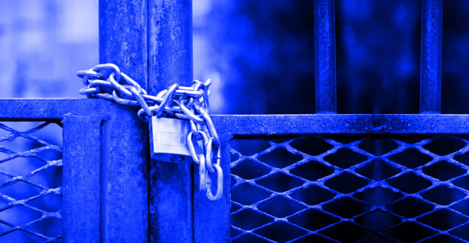 Factory gate closed with padlock.