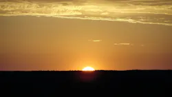 The sun rising over the Australian Desert The cool of the night was about to vanish in a wave of heat as the brightening light washed over the desert and Ayers Rock The sun rising over the Australian Desert The cool of the night was about to vanish in a wave of heat as the brightening light washed over the desert and Ayers Rock
