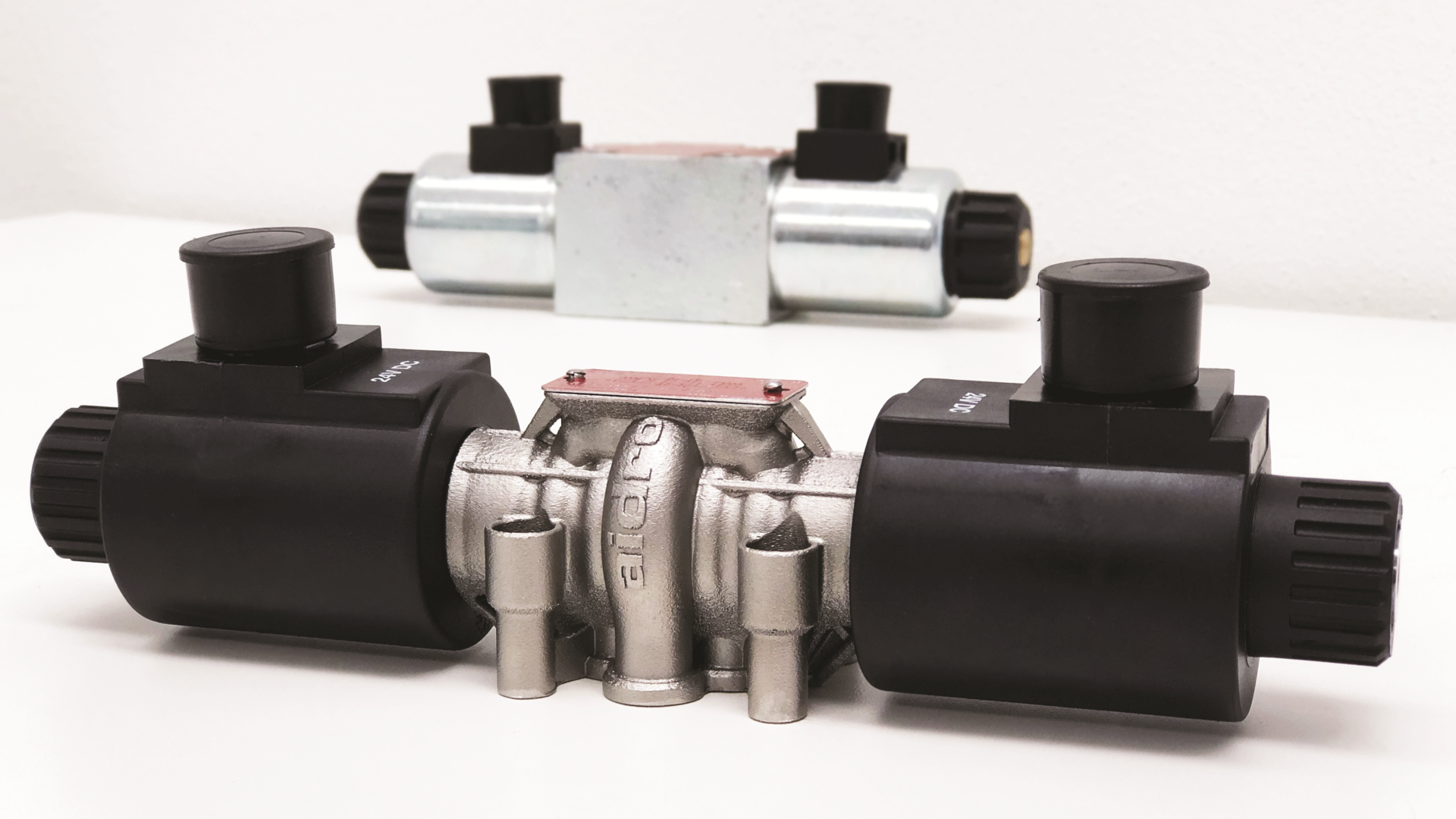 A comparison of the design changes possible with 3D printing. The valve in the foreground is 3D printed while the one in the background is manufactured using traditional methods.