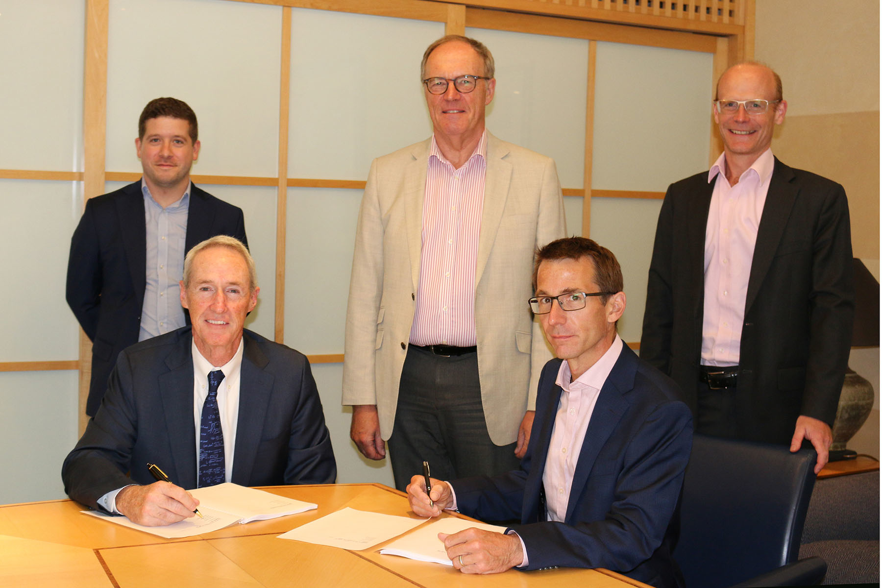 Executives from the companies signing the acquisition agreement