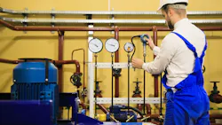 Engineer adjusts pressure sensors on industrial refinery plant Engineer adjusts pressure sensors on industrial refinery plant