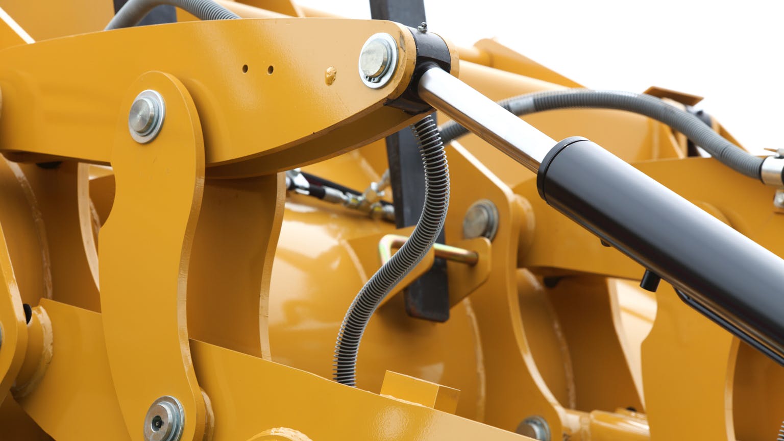 A close up of hydraulic cylinders on a piece of construction machinery