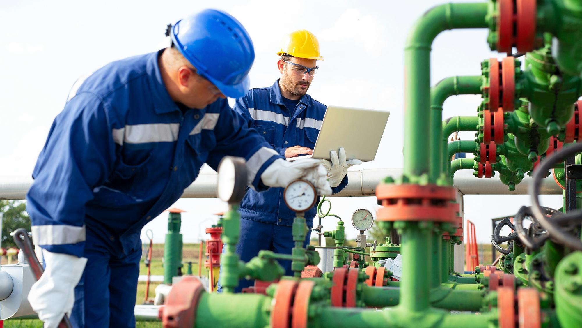 An image of maintenance workers examining some piping and other components