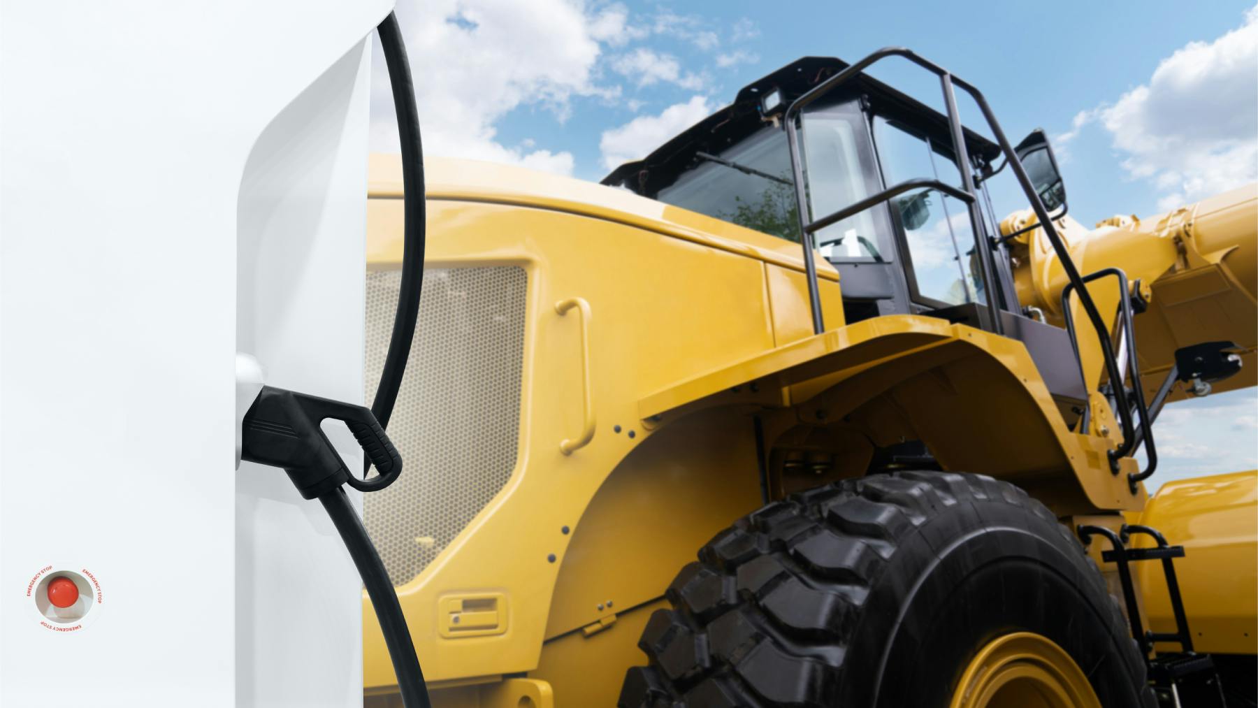 A close up view on a wheel loader with an electric charger next to it