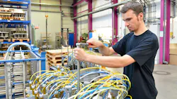 A man works on a system assembly of hoses and cylinders A man works on a system assembly of hoses and cylinders