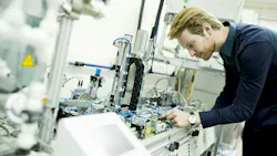 A man evaluates components in a manufacturing facility A man evaluates components in a manufacturing facility