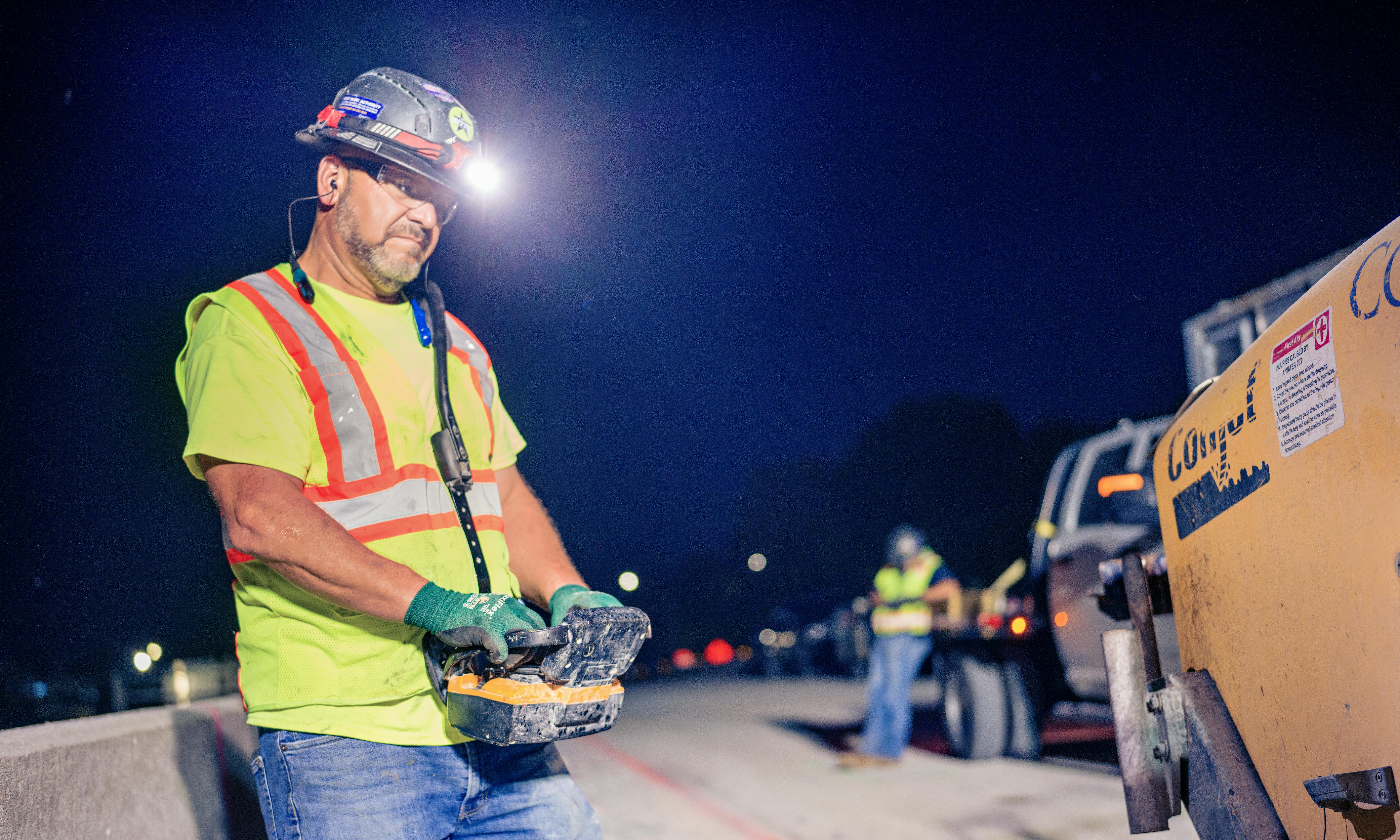 A construction worker remotely controlling a machine on a job site