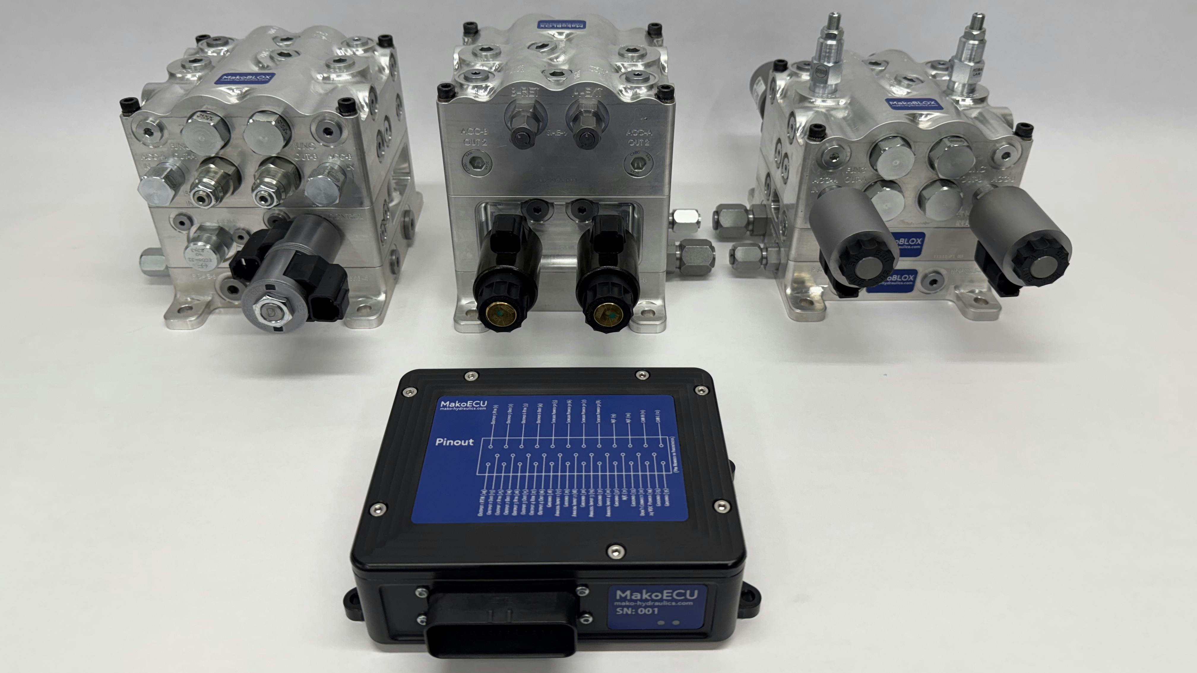 The ECU in front of three manifold types available in the Mako Hydraulics development kit