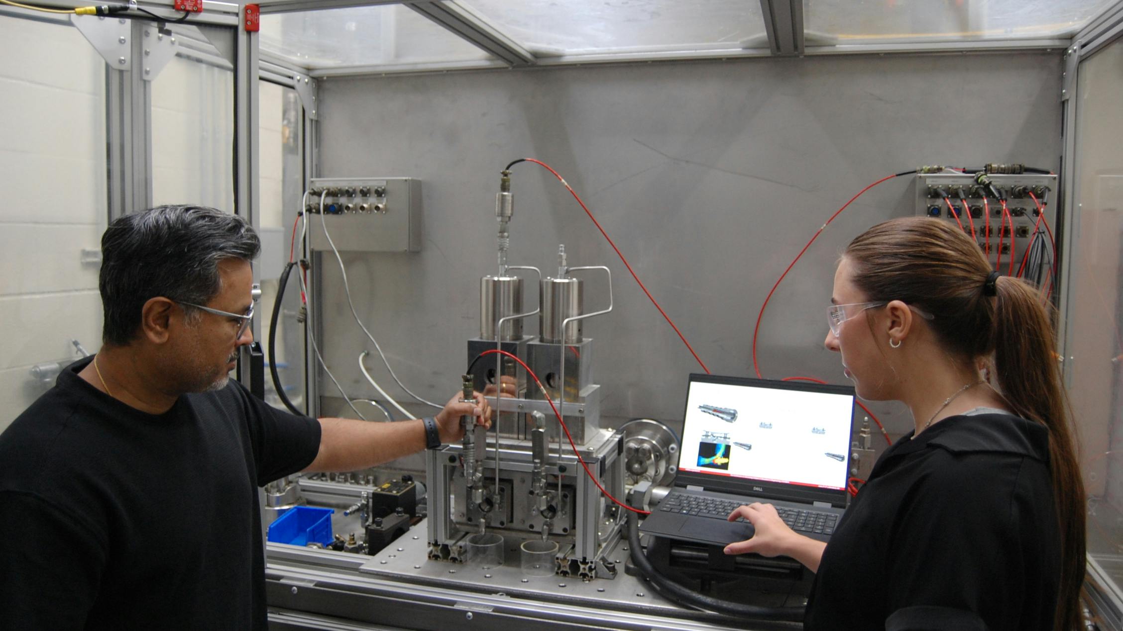 Bipin Kashid (left) and intern turned employee Jenna Watts (right) working on subsea oil and gas test stand
