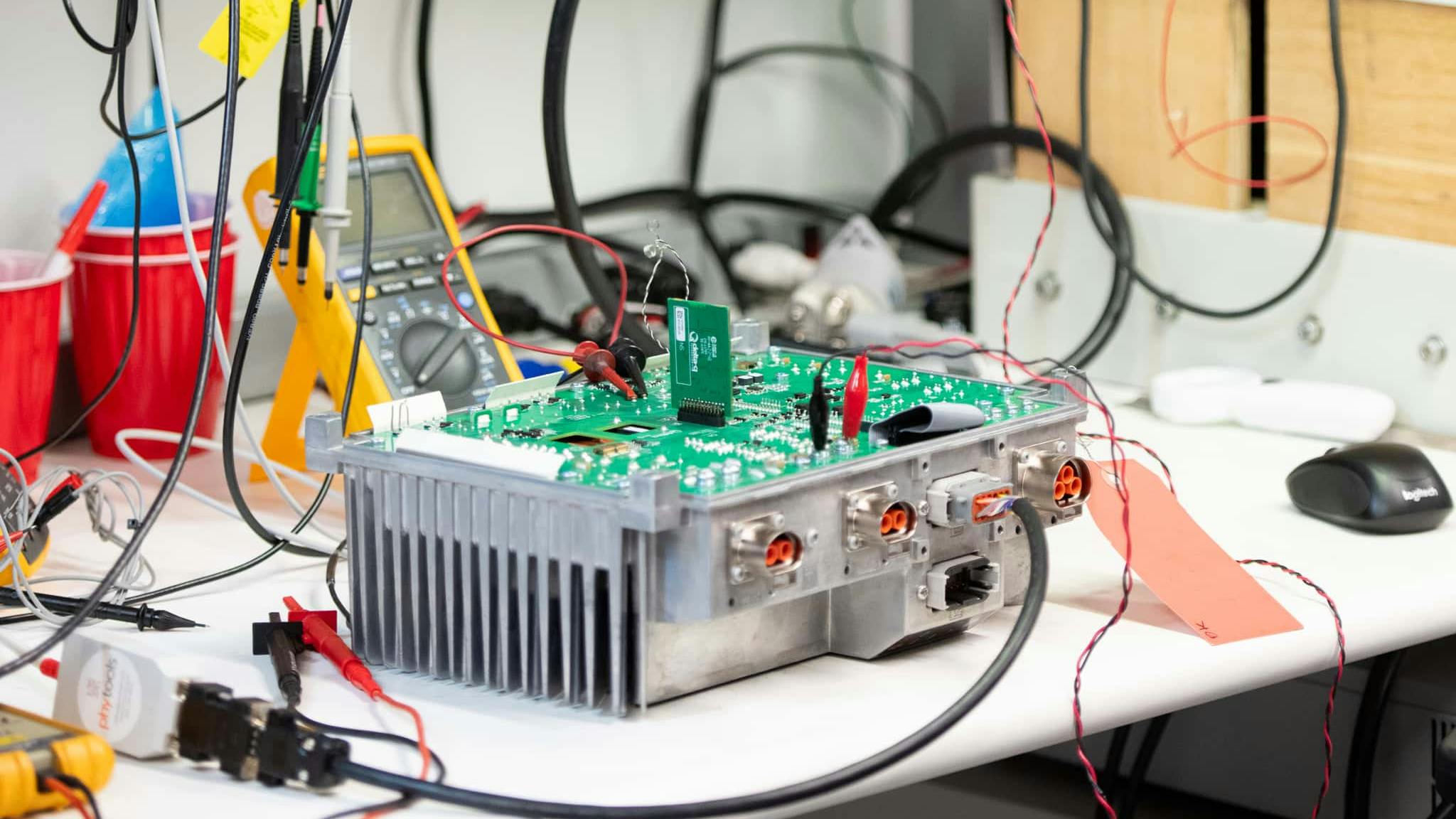 A battery in a testing laboratory with wires and testing equipment hooked up to it