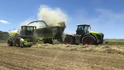 Tractor and Harvester working alongside each other in farm field Tractor and Harvester working alongside each other in farm field