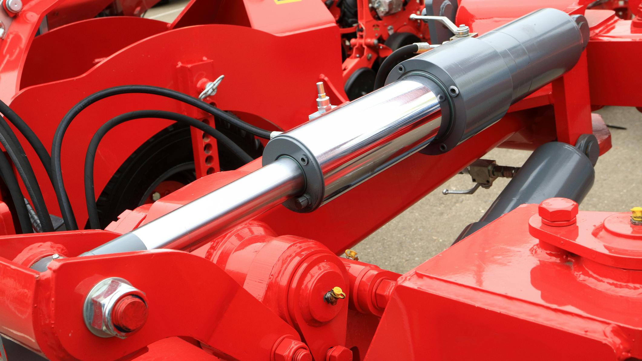 Close up on a hydraulic cylinder and other fluid power components on a machine