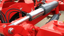 Close up on a hydraulic cylinder and other fluid power components on a machine Close up on a hydraulic cylinder and other fluid power components on a machine