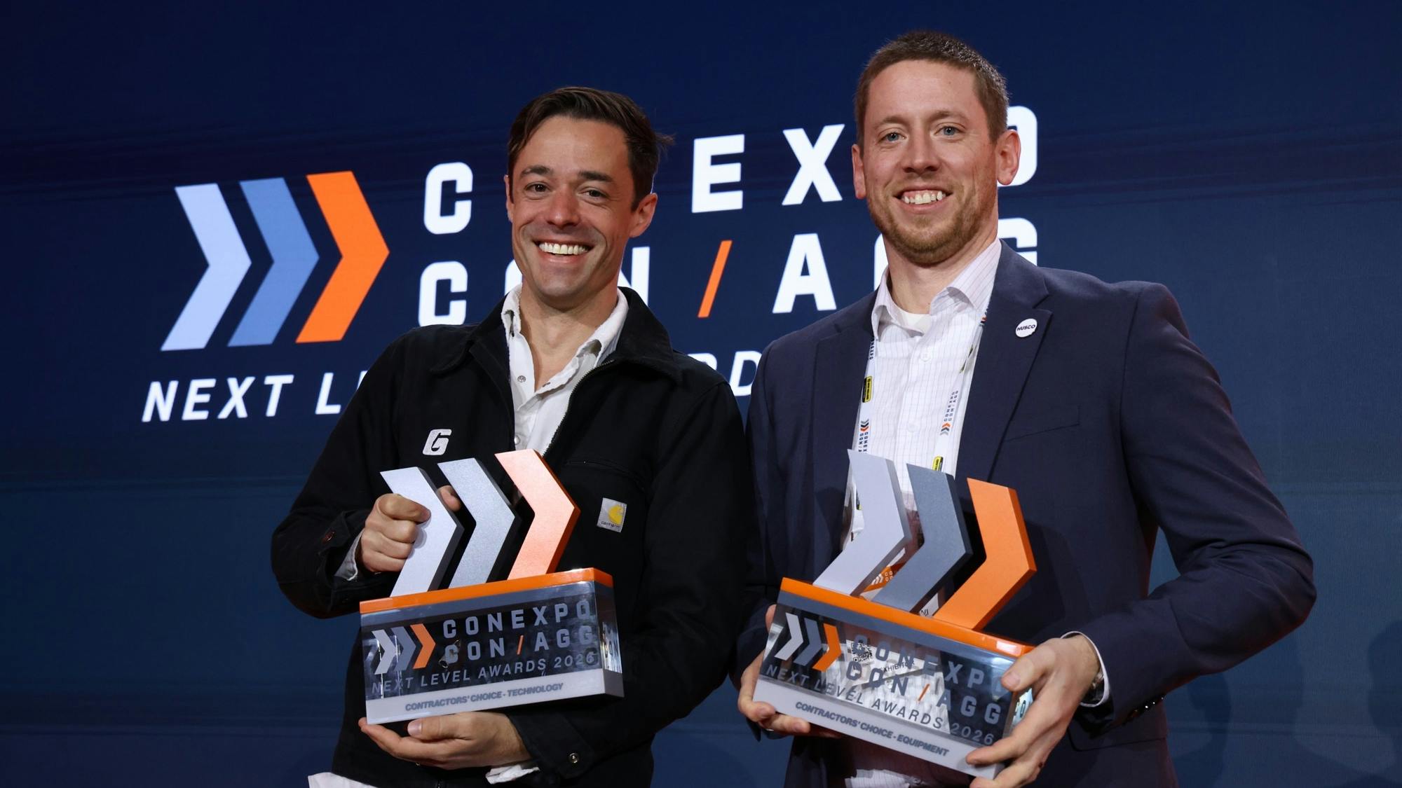 Ryan Luke Johns of Gravis Robotics (left) and Ben Holter, from Husco (right) holding their CONEXPO Next Level Awards