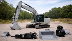 An excavator with various types of hydraulic attachments in the foreground An excavator with various types of hydraulic attachments in the foreground