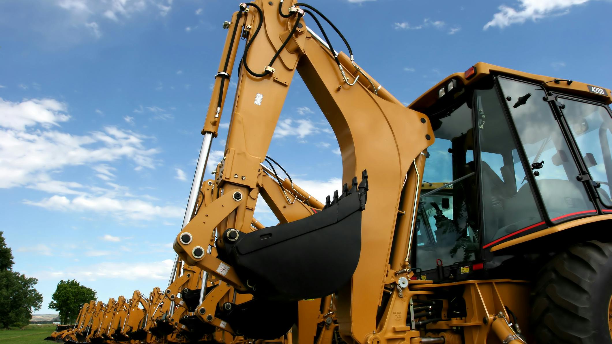 Back view of several backhoes lined up