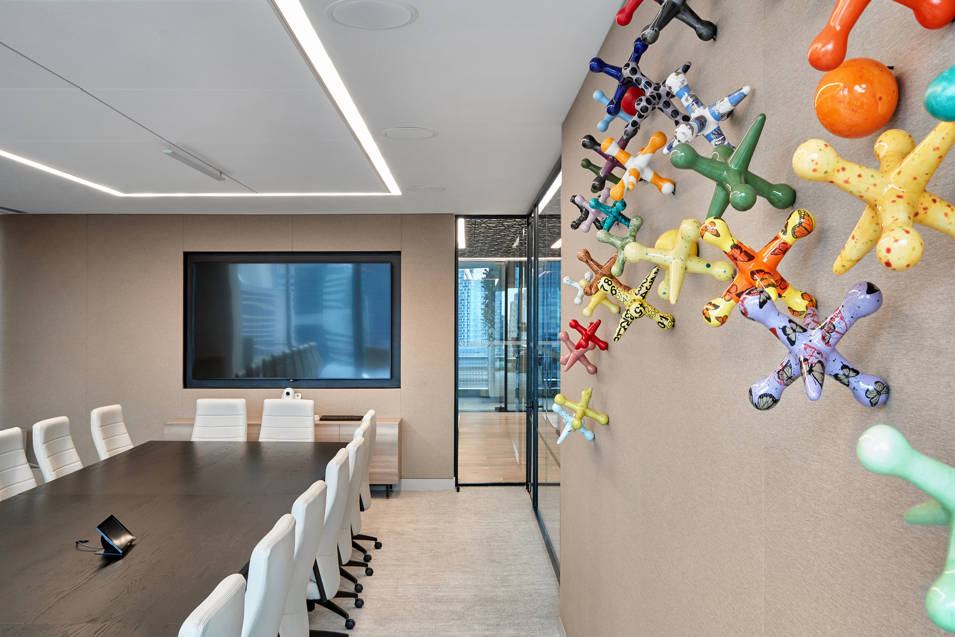 A vibrant wall sculpture featuring colorful, enlarged jacks that spill across the wall in a conference room keeping employees engaged and excited to interact.