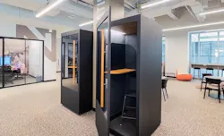 A set of privacy pods/phone booths with offices in the background. A set of privacy pods/phone booths with offices in the background.
