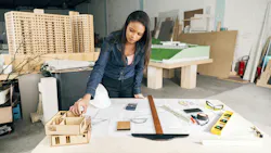 Interior designer considers a scaled 3D model of project Interior designer considers a scaled 3D model of project