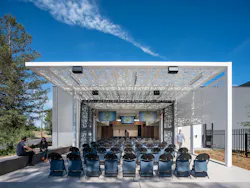 Outdoor training space with rows of seating beneath white, metallic trellis. Outdoor training space with rows of seating beneath white, metallic trellis.