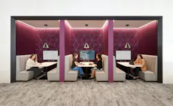 HGA employees work in booths adorned with a plum-colored backdrop, a signature hue of the company's branding. HGA employees work in booths adorned with a plum-colored backdrop, a signature hue of the company's branding.