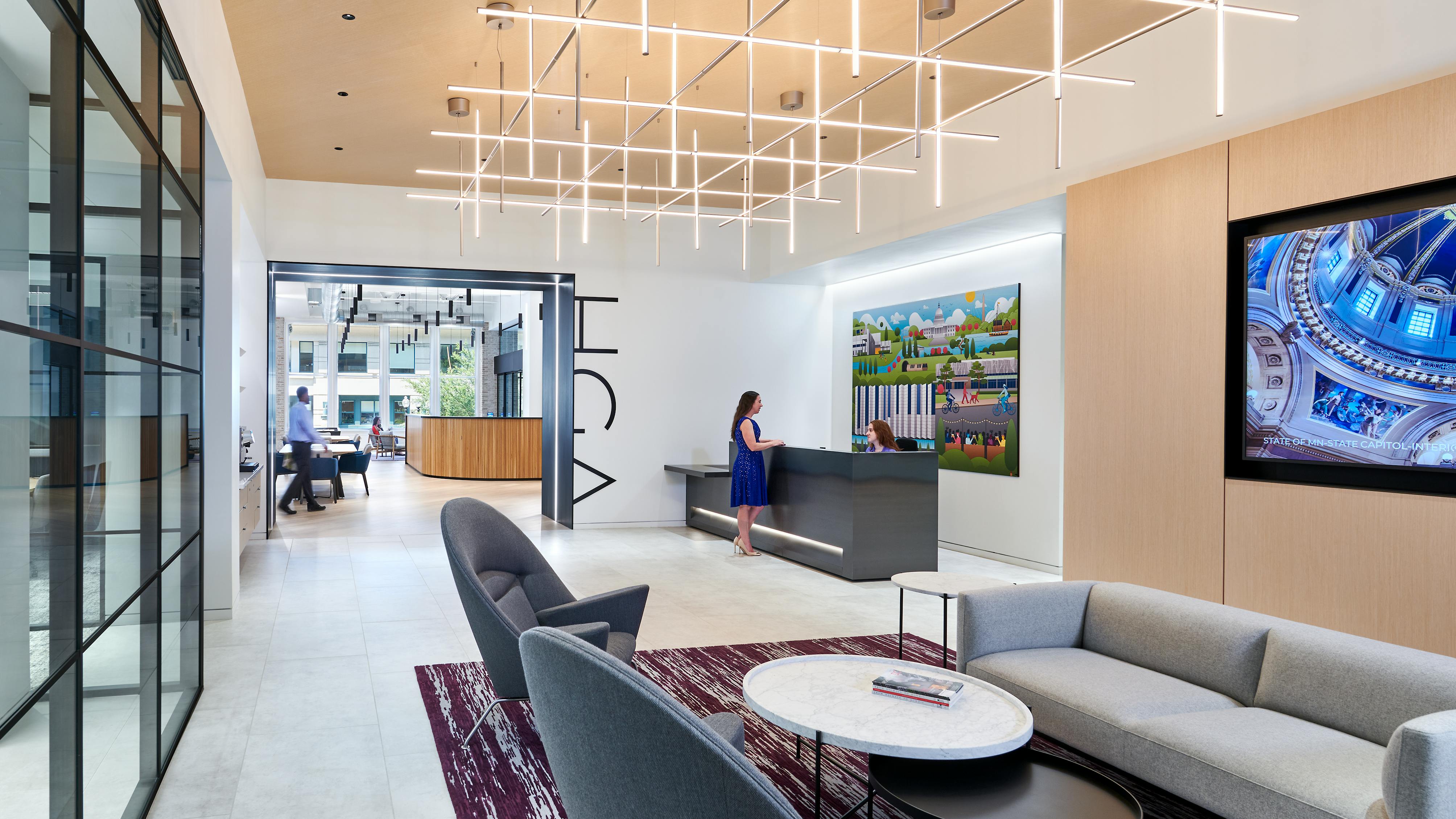 The entrance to HGA's office features a waiting area and a reception desk. The company name is displayed on the wall leading into the office space.