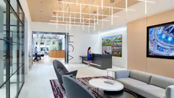 The entrance to HGA's office features a waiting area and a reception desk. The company name is displayed on the wall leading into the office space. The entrance to HGA's office features a waiting area and a reception desk. The company name is displayed on the wall leading into the office space.